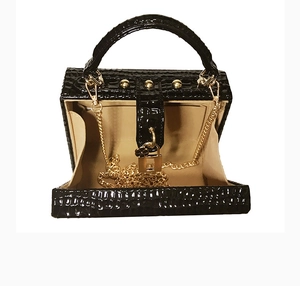 Détail du sac boîte noir ouvert motif serpent avec poignées en métal doré élégant