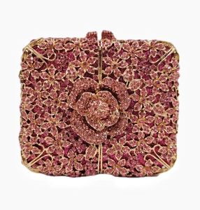 Close-up of pink crystal flowers and intricate rhinestones on a gold evening clutch bag