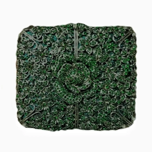 Macro shot of green floral pattern with intricate metal details on the evening clutch