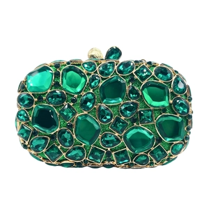 Detail of emerald green crystal encrusted clutch bag with gold metallic frame and clasp
