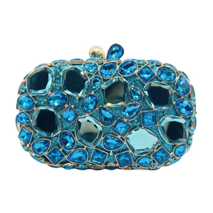 Detail view of luxury blue clutch with vibrant rhinestones and elegant gold metal frame