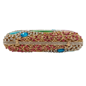 Détail de pochette évidée dorée de luxe avec strass roses et pierres précieuses colorées
