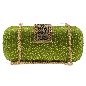 Detail of green rhinestone evening clutch bag with gold metal chain and emerald gem buckle
