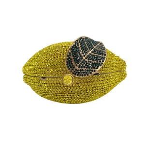Close-up of yellow lemon evening bag with sparkling crystals and green leaf metal clasp