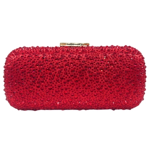 Macro shot of sparkling red rhinestones and golden metal buckle on evening clutch bag