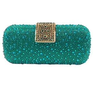 Detail view of emerald green rhinestone evening clutch with gold metal clasp closure