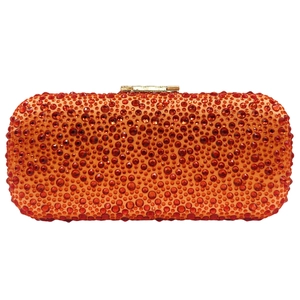 Detail of red and orange crystals on a luxury evening clutch with gold metal clasp