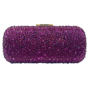 Detail of purple evening clutch bag with sparkling rhinestones and gold metal clasp