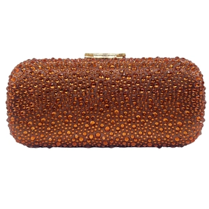 Detailed view of luxury amber orange clutch bag with full rhinestones and gold clasp