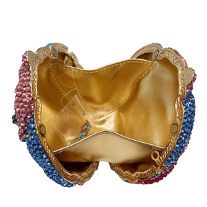Macro view of crystal evening clutch with colorful rhinestones and gold leather lining