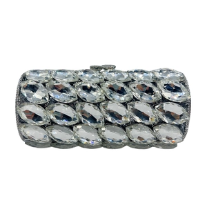 Close-up of sparkling oval crystals and silver metal frame on cylindrical evening bag