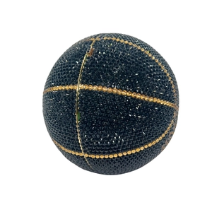 Macro shot of luxury black basketball-shaped evening bag with gold crystal line detail