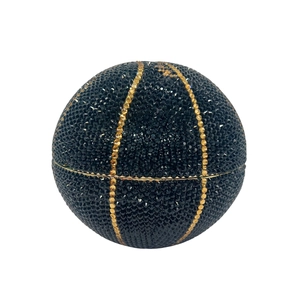 Close-up of black basketball shaped evening clutch bag with sparkling crystals and gold trim