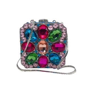 Macro detail of luxury silver clutch with colorful oval crystals and blue rhinestones