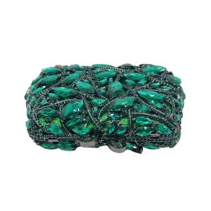 Macro detail of emerald green crystals and marquise gems on luxury evening clutch bag