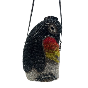 Close-up of a penguin-shaped clutch bag encrusted with multi-color sparkling rhinestones
