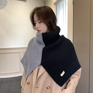 Detail view of the gray and black contrast knit texture on a high neck split shawl wrap