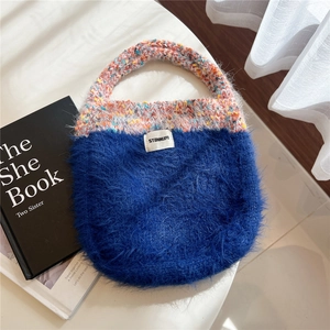 Detail of cute navy faux fur and mixed knit tote bag featuring a stitched white label