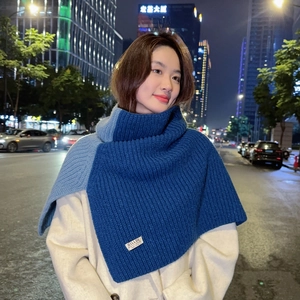 Detail of blue color-block knit snood featuring ribbed texture and stylish high neck collar