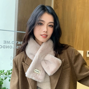 Gros plan d'un cache-cou en fausse fourrure rose clair avec un manteau en laine marron