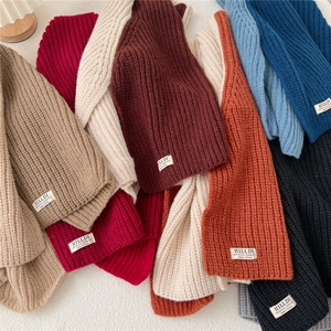 Detailed macro of assorted knit scarves in various colors with vertical ribbing texture