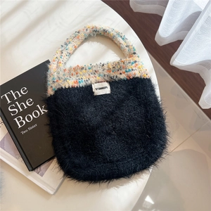 Detail of cute knitted mixed-color handle and black plush bottom on stylish tote bag