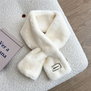 Détail d'une écharpe en fausse fourrure crème avec texture douce et plaque métal