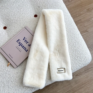Gros plan sur la texture d'une écharpe en fausse fourrure beige avec étiquette de marque