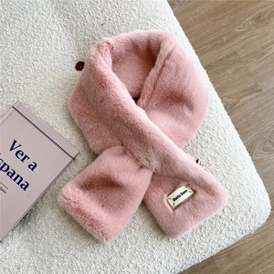 Gros plan d'une écharpe rose en fausse fourrure avec un design croisé et étiquette