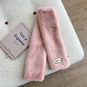 Détail de l'écharpe en fausse fourrure rose avec étiquette Doria Dore et fente croisée