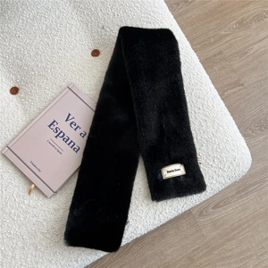 Gros plan d'une écharpe en fausse fourrure noire avec étiquette de marque textile