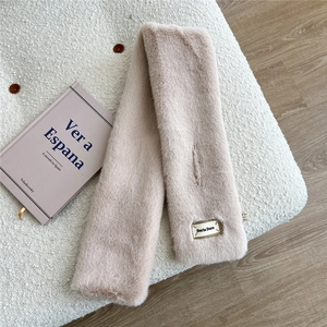Gros plan d'une écharpe en fausse fourrure rose pâle avec étiquette de la marque