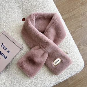 Gros plan d'une écharpe en fausse fourrure rose avec texture douce et étiquette Doria