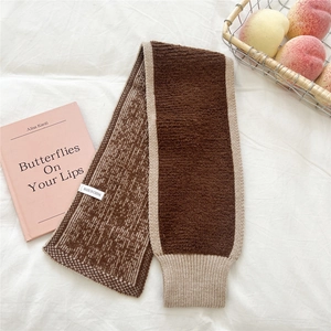 Detaillierte Nahaufnahme des dicken Strickschals mit zweifarbigem Design und Rippstrick