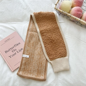 Detailansicht des zweifarbigen Strickschals mit braunem Lammfell und weißem Strickrand