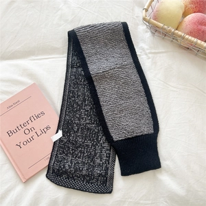 Detail eines Strickschals für den Winter mit grauem Webmuster und schwarzem Ripprand