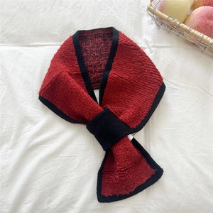 Detailansicht des rot-schwarzen Überkreuz-Strickschals aus warmem Chenille-Stoff