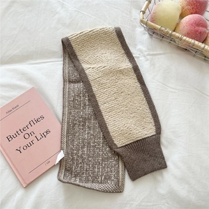 Detail der groben Strickstruktur und zweifarbigen Nähte am weichen Winterwärmer