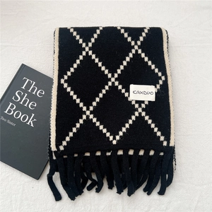 Close-up of black and white Argyle knit scarf with decorative long tassel fringe edges