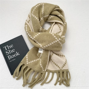 Detail of diamond pattern knit scarf with fringe tassels and woven texture