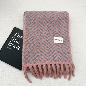 Close-up of pink and grey herringbone knit scarf with long tassels and branded label