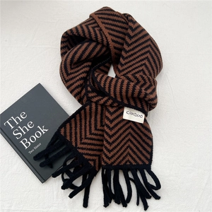 Close-up of brown and black chevron knit scarf with fringe and white brand label
