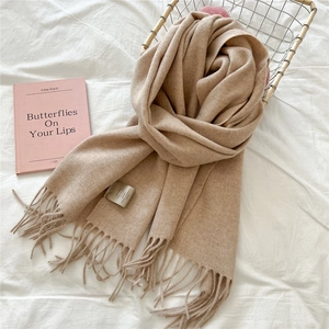 Detail of soft camel wool scarf with elegant tassel design and authentic care label