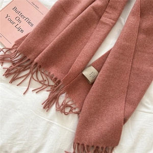 Detail of grey-pink 100% wool scarf showing soft texture and delicate fringe trim