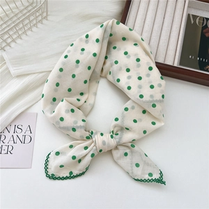 Cream linen neck scarf with green polka dots and crochet lace trim in a knotted style