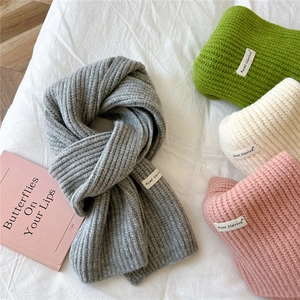 Detail of soft knitted scarves in grey, green, beige and pink with vertical texture