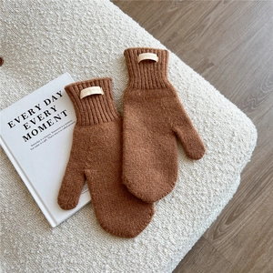 Detail of 100% wool knitted mittens in caramel brown with ribbed cuff for winter warmth