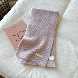 Detail of soft knit scarf with mixed pink texture and DORIA DORE fabric care label