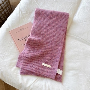 Macro view of heather pink knitted scarf showing rib texture and brand label