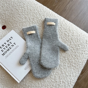 Close-up of grey knit mittens featuring soft fuzzy texture and ribbed elastic cuffs